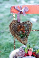 Heart wreath with Ilex - Holly sprigs, tied to red chair