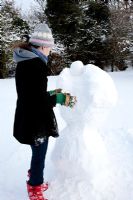 Teenage girl building snow angel