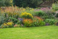 Large late summer herbaceous border with Crocosmia, Macleaya, Aconitum, Achillea, Rudbeckia and Solidago with lawn at 'Springbank', Davenham, Cheshire NGS