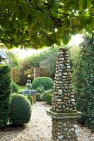 Gravel path with stone obelisk focal point, Taxus baccata - Yew hedge and Buxus - Box spheres. Silverstone Farm, Norfolk