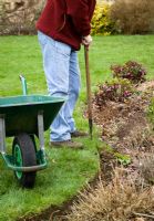 Redefining a lawn edge using a half moon shaped cutter, also known as half-moon iron