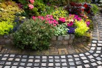 Reclaimed cobbles and bricks used to make path and raised border with mixed rich late summer planting including Parahebe, Begonia, Impatiens, Lamium, Lobelia and Heuchera. Brocklebank Road, Southport, Lancashire NGS