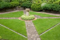 Bird bath surrounded by Pachysandra terminalis and lawn, paths made from reclaimed cobbles and bricks, raised beds with dense planting of shrubs and conifers - Brocklebank Road, Southport, Lancashire NGS