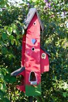 Red bird house with bird