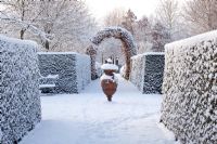 Clipped Taxus hedge, Fagus arch and ornate urn - Winter Garden and Nursery