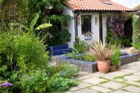 Moroccan style garden with blue tiled pool and drought tolerant plants including Phormium, Musa basjoo and Bamboo