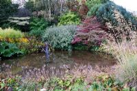 Landscaped pond with sculpture in autumn -  Lady Farm, Somerset