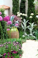 Allium, Osteospurmum, Lavandula stoechas and oil jar with Agave - Das Vagos 'Lazy Days' garden at RHS Chelsea Flower show 2006