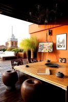 Terrace with contemporary seating area with sofas and orange painted walls in Ferrara, Italy