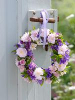 Hanging wreath with Roses, Campanulas, Thyme, and mint tied with ribbon on door