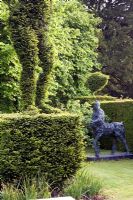 Deborah's sculpture of 'The Fifth Horseman' next to her Box topiary sculptures in the 'Sculpture Garden' - Cantax House, Wiltshire. 