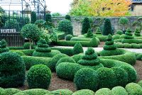 Clipped Buxus - Box and Taxus - Yew in the Parterre Garden with  standard Laurels and a gazebo and gates by Richard Overs. Bourton House, Bourton-on-the-Hill, Moreton-in-Marsh, Glos, UK