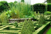 Geometric knot garden of Buxus - Box framed within Taxus - Yew walls, with central basket pond from the Great Exhibition of 1851. Bourton House, Bourton-on-the-Hill, Moreton-in-Marsh, Glos, UK