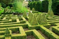 Geometric knot garden of Buxus - Box within Taxus - Yew walls, with central basket pond from the Great Exhibition of 1851. Bourton House, Bourton-on-the-Hill, Moreton-in-Marsh, Glos, UK 