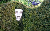 Classical face sculpture in Yew Hedge, Tilford Cottage, Surrey  