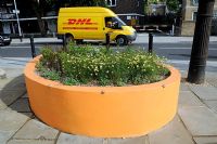 Colourful yellow gold street planter with matching plants, Holloway, London Borough of Islington.