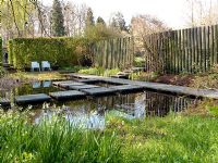 Natural wildlife pond with decked stepping stones. Mien Ruys Tuinen, Dedemsvaart, Netherlands 
