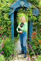 Tina Primmer with her miniature poodle. Poppy Cottage Garden, Roseland Peninsula, Cornwall, UK