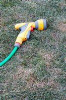Garden hose nozzle on a frosty lawn