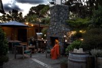 Exterior fireplace and entertaining area. Laurus - Bay trees and Cyathea dealbata - Tree Ferns. New Zealand