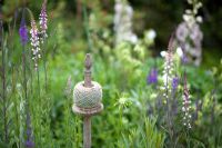 Ball of string on a wooden post surrounded by cottage planting of Linaria Purpurea 'Canon Went' and Delphinium 'Sandpiper'.  Lychnis coronaria and Stachys lanata in the front.