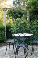 Circular patio backed by Hydrangea quercifolia and stone columns