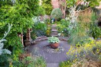 Garden with Hosta in pot at centre of a circular walkway - Poplar Grove