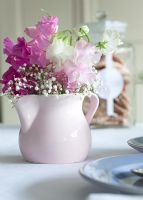 Table with Lathyrus - Sweet Peas and Gypsophila - Babys Breath in pink jug
