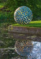 Sculpture on lawn next to pond
