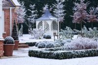 Formal town garden with gazebo covered in snow, Oxford, UK. 
