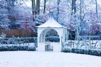 Formal town garden with gazebo covered in snow, Oxford, UK. 
