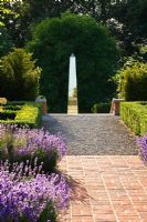 Garden with red brick Lavandula - Lavender, edged path leading to metal sculpture, Oxfordshire 
