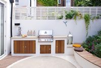 Small patio garden with raised bed and built in outdoor kitchen and barbecue. 