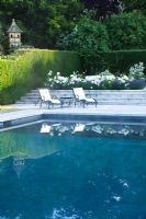 Swimming pool with loungers and white border