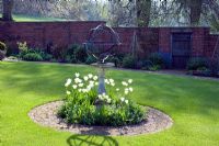 Sundial with white tulips in lawn