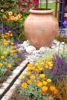 Water feature and decorative terracotta urn in garden 