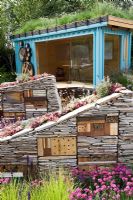 Garden studio with green roof and insect hotels built in to dry stone walls 