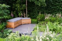 Polished concrete patio with seating area and Carpinus - Hornbeam hedging in 'The Lands End Across the Pond Garden' - Gold Medal Winner, RHS Chelsea Flower Show 2011
