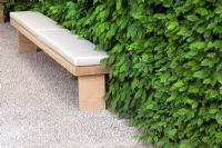 Upholstered wooden bench on gravel path - The Laurent-Perrier Garden - Nature and Human Intervention - Gold Medal Winner, RHS Chelsea Flower Show 2011