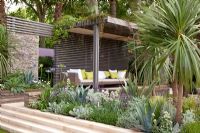 Paved steps up to seating area, pavilion with 'living roof', and raised borders of maritime plants - The Cancer Research UK Garden, Silver Gilt Medal Winner, RHS Chelsea Flower Show 2011 
