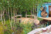 Wildlife garden with seating area under Betula - Silver Birches in 'The Royal Bank of Canada with the RBC New Wild Garden' - Silver Gilt Medal Winner, RHS Chelsea Flower Show 2011 