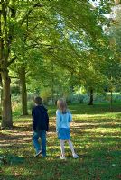 Children walking in the garden in October at Chippenham Park, Cambridgeshire on an NGS open day.