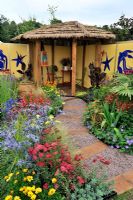 Contrasting and vibrant colour planting with thatched shelter area in the 'Painting With Plants Garden' - RHS Tatton Park Flower Show 2011