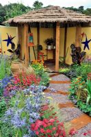 Contrasting and vibrant colour planting with thatched shelter area in the 'Painting With Plants Garden' - RHS Tatton Park Flower Show 2011
