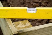 step by step, making a raised bed - using spirit level to ensure boards are level