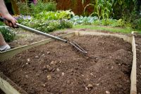 step by step, making a raised bed - levelling soil in raised bed