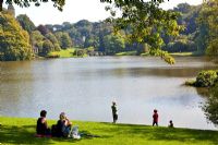 View across lake to the Palladian Bridge and St Peter's Church at Stourhead Gardens, Wiltshire, UK, early September, Designed by Henry Hoare
 