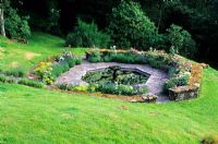 Octagonal pool with fountain surrounded by Rosa 'Mary Rose', Alchemilla mollis and Lavender - High Glanau Manor, Monmouthshire, Wales 
