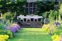 View up Herbaceous borders to dining area at side of house  - High Glanau Manor, Monmouthshire, Wales 