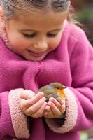 Girl with Robin held in hands.